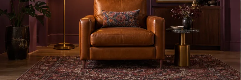 Illustrative caramel leather chair and brass floor lamp in an aubergine room