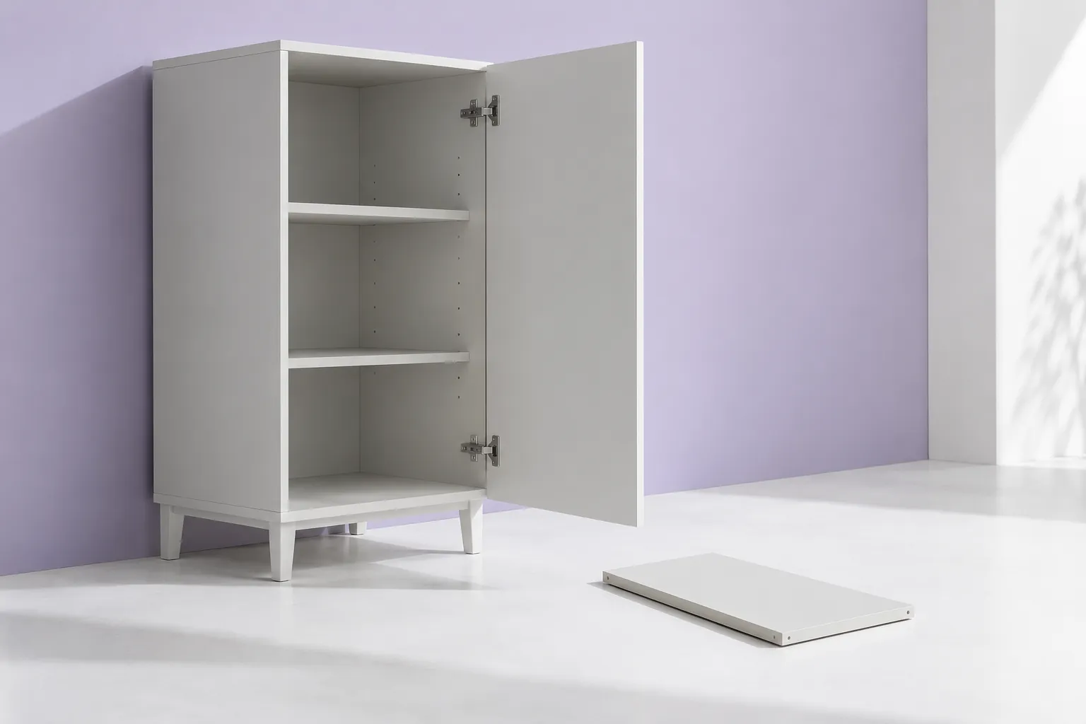 Open white cabinet with interior shelves and a separate panel on the floor.
