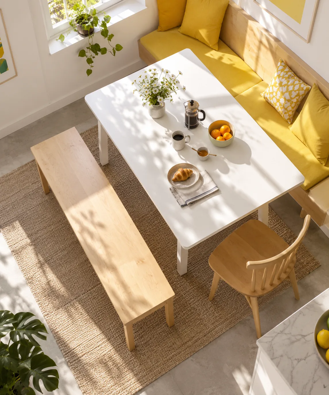 Overhead view of a sunny breakfast nook with a pale timber bench and mustard cushions.