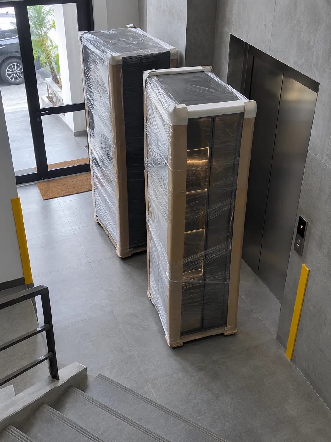 Wrapped bar cabinet sections beside a Lagos apartment lift